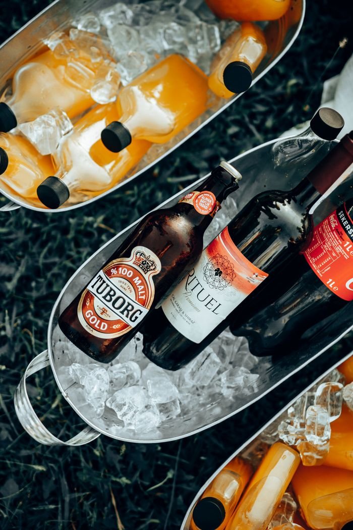 contact-img Overhead view of bottles of beer and juice chilling in ice buckets. Perfect for outdoor summer gatherings.